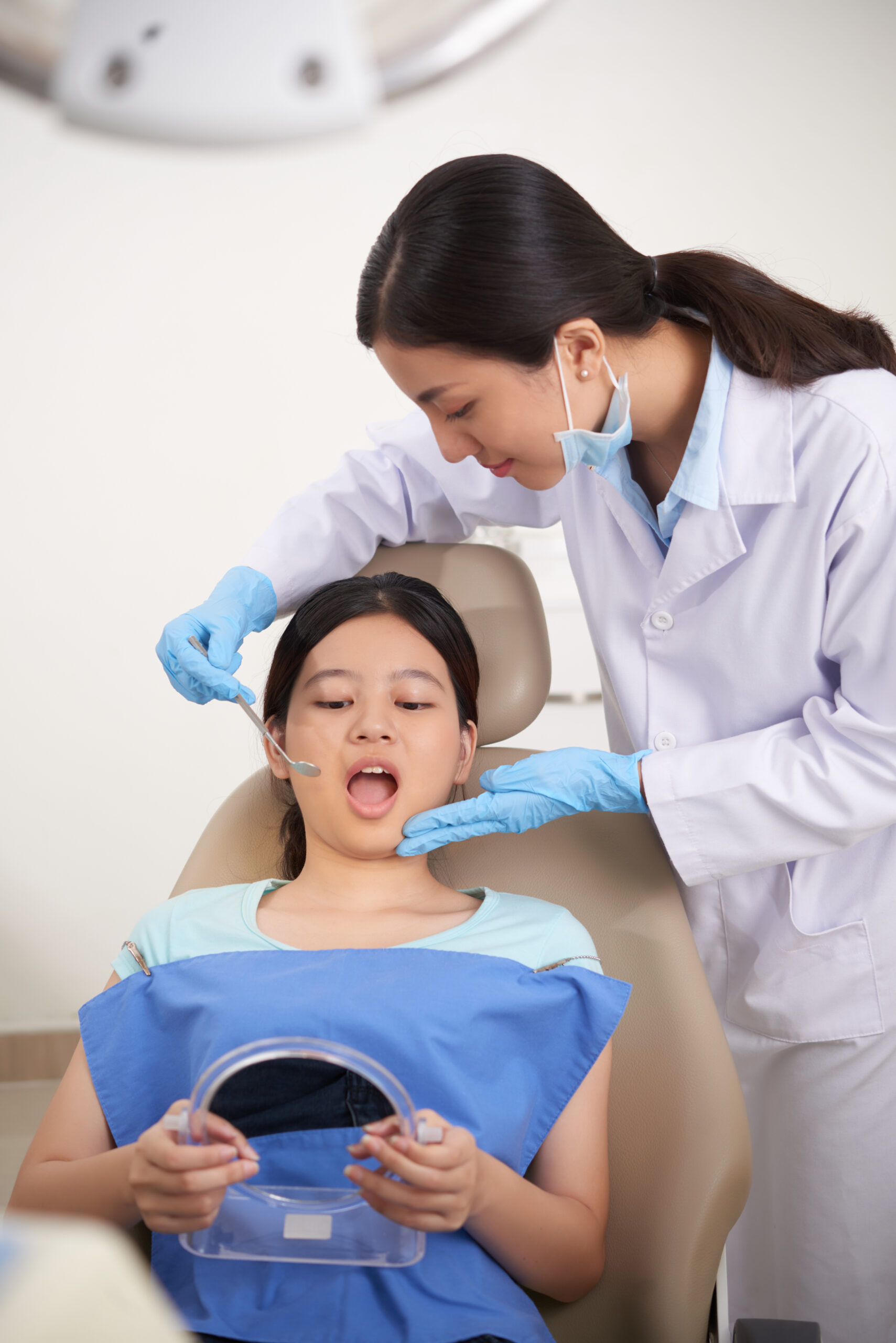 Girl opening mouth so dentist could examine her teeth