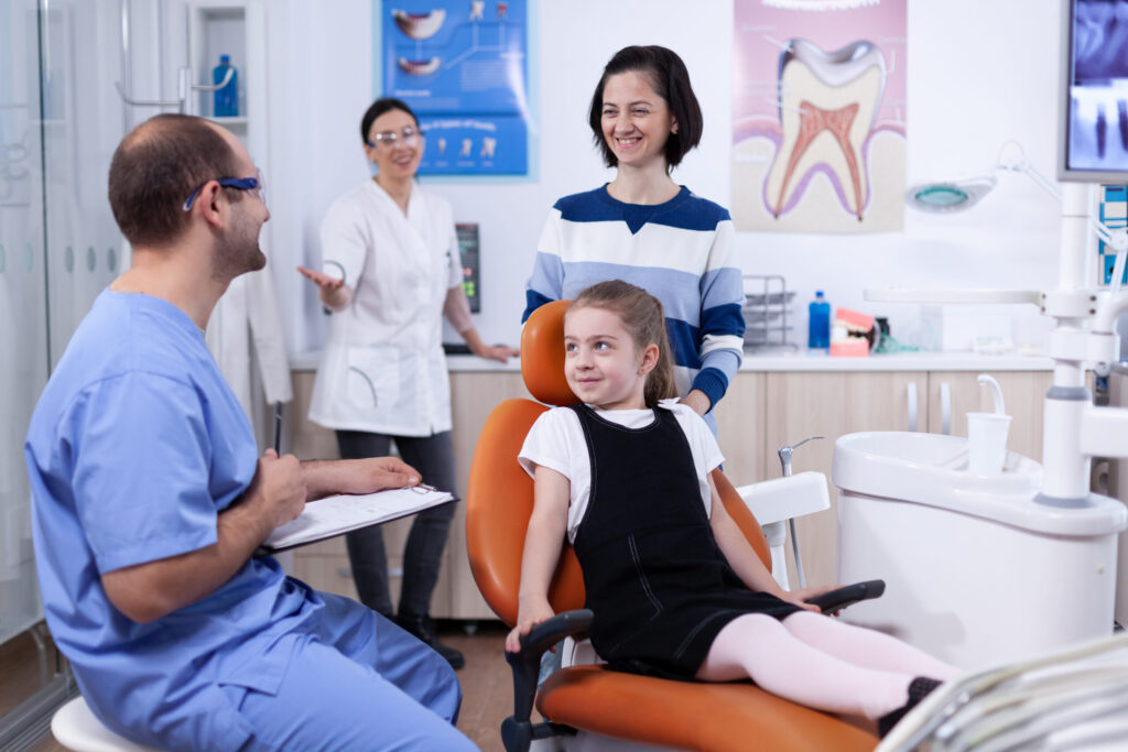 Dentist assistant giving good news to kid parent